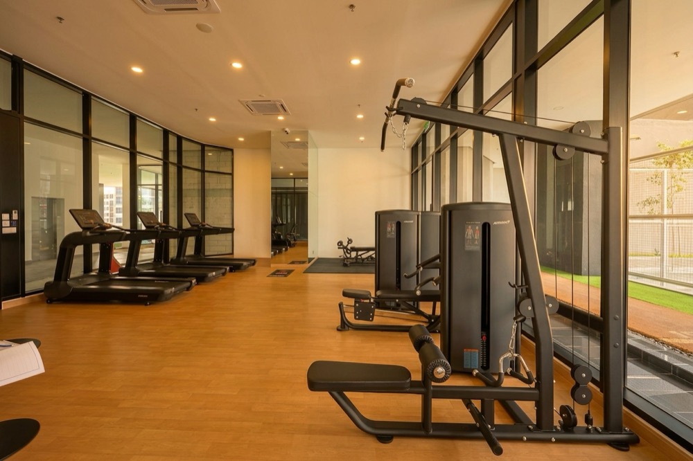 Gymnasium at BeCentral — treadmills and strength equipment with city view